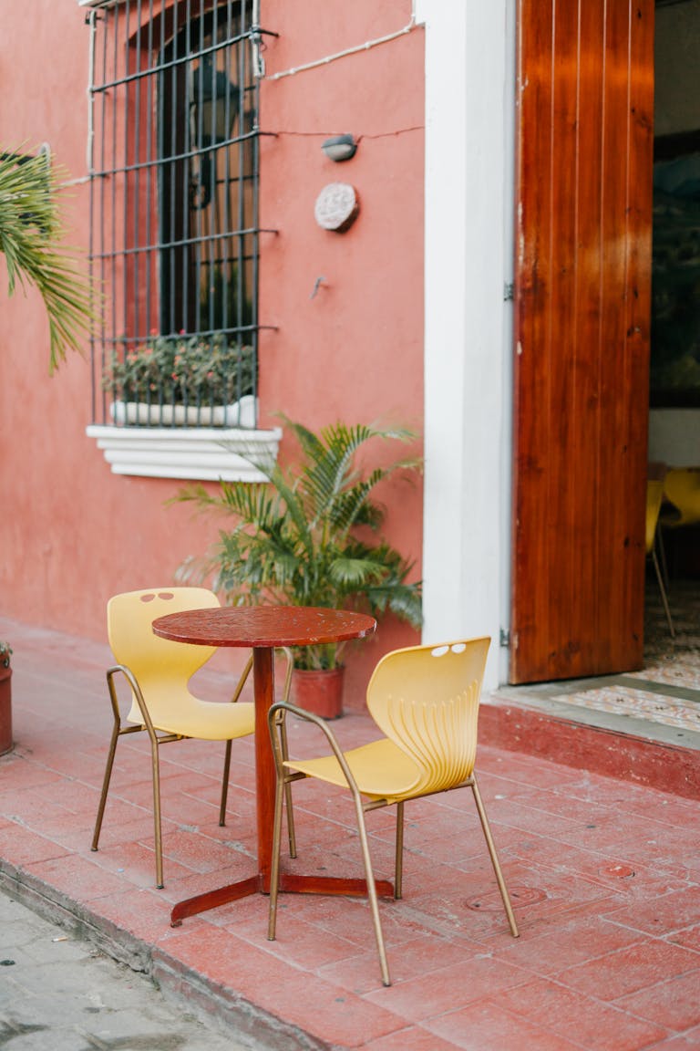 Charming outdoor seating at a café with tropical plants and vibrant colors.
